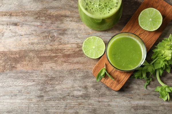 Glassware with delicious detox juice and ingredients on wooden background, top view