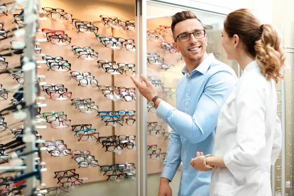 Женщина Офтальмолог Помогает Мужчине Выбрать Очки Оптическом Магазине — стоковое фото