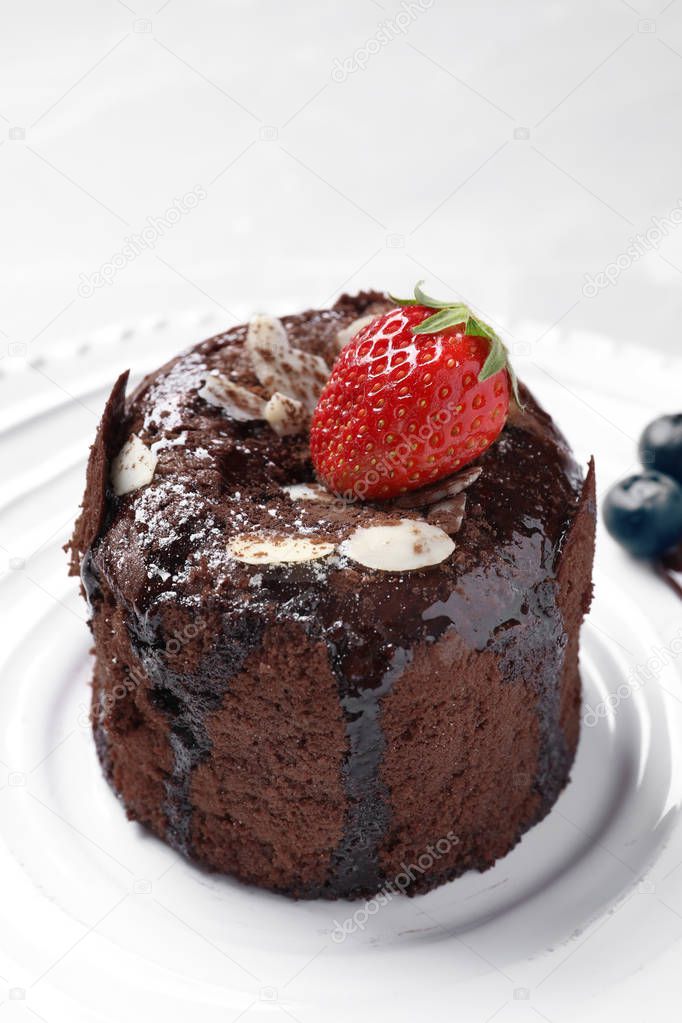 Delicious fresh fondant with hot chocolate and berries served on plate. Lava cake recipe