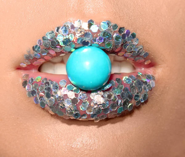 美丽的年轻模特与奢侈的化妆举行糖果在嘴唇 — 图库照片