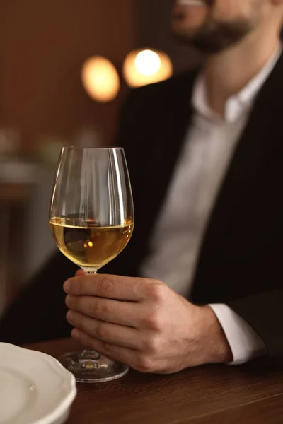 テーブルでレストランでワインのグラスを持つ男 — ストック写真