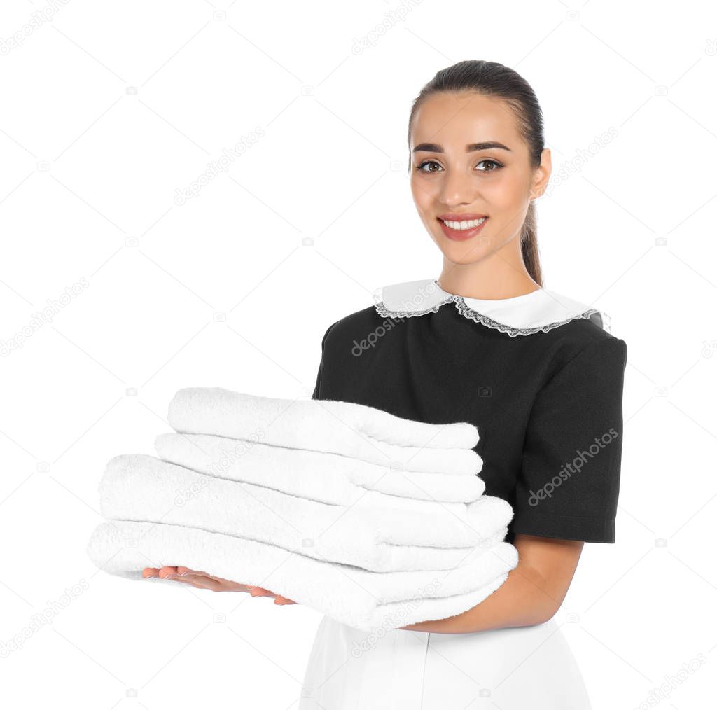 Young chambermaid with stack of clean towels on white background