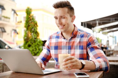 Laptop ile resepsiyon kafede çalışan genç adam