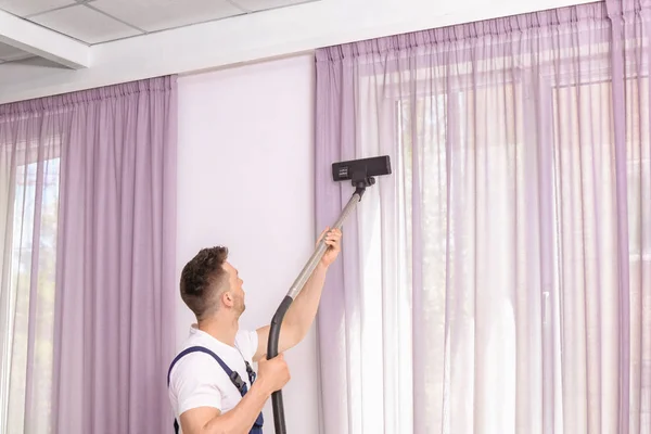 Male Worker Removing Dust Curtains Professional Vacuum Cleaner Indoors — Stock Photo, Image