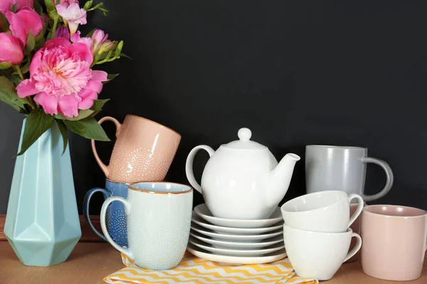 Uppsättning Porslin Och Vas Med Blommor Bordet Nära Svarta Tavlan — Stockfoto