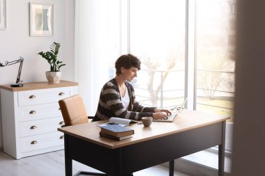 Laptop ile masa başında çalışan genç kadın. Ev ofis