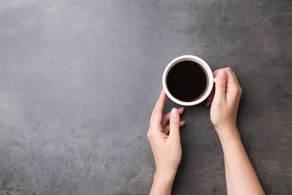 上面ビュー 灰色の背景においしいホット コーヒーのカップを持つ若い女性 — ストック写真