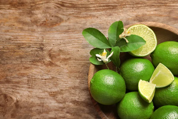 Kom Met Verse Rijpe Limes Houten Achtergrond Bovenaanzicht — Stockfoto