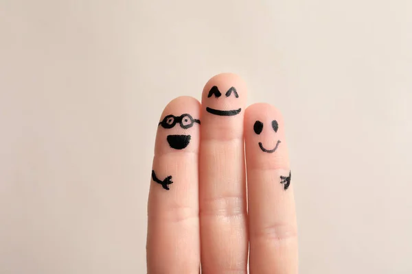 Fingers with drawings of happy faces against light background. Unity concept