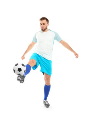Genç adam beyaz arka planda futbol oynuyor.