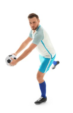 Genç adam beyaz arka planda futbol oynuyor.