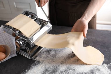 Genç adam Erişte makarna üreticisi masada üzerinde hazırlanıyor