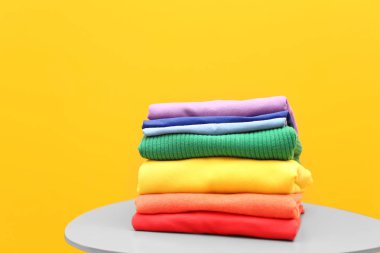 Gökkuşağı giyim renk arka plan karşı masada yığını