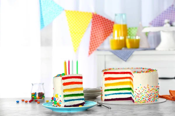 パーティー テーブルの上の蝋燭とおいしい虹のケーキ — ストック写真