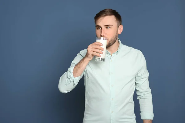 背景色でおいしい牛乳を飲む若い男 — ストック写真
