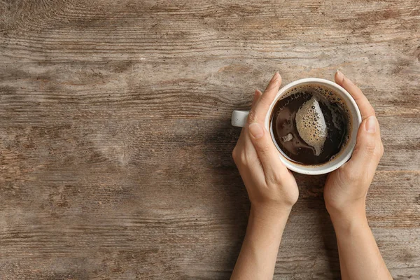 Jonge Vrouw Met Een Kopje Heerlijke Warme Koffie Houten Achtergrond — Stockfoto