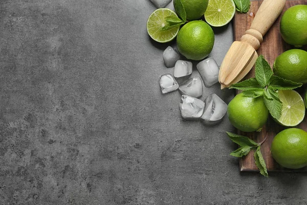 Plat Lag Samenstelling Met Rijpe Limes Ijsblokjes Juicer Grijze Achtergrond — Stockfoto