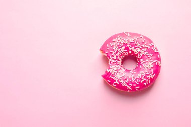 Lezzetli ısırıldı halka ile sprinkles renk arka plan, üstten görünüm