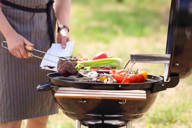 Pişirme et ve sebze Barbekü ızgara açık havada Genç adam