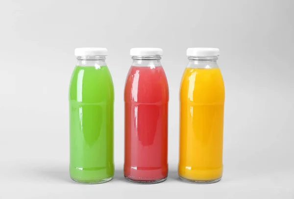 Butelki Pyszne Soki Kolorowe Jasnym Tle — Zdjęcie stockowe