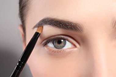 Genç kadın kaş şekli fırça, closeup ile düzeltme