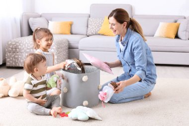 Ev hanımı ve çocukları evde oynadıktan sonra oyuncakları toplama