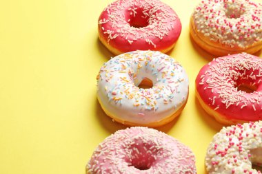 Renk arka plan üzerinde sprinkles ile lezzetli sırlı çörek