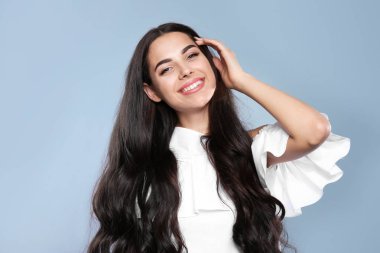 Gri arka plan üzerinde muhteşem kıvırcık saçlı güzel model portresi