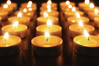 Karanlıkta yanan mumlar, yakın plan.