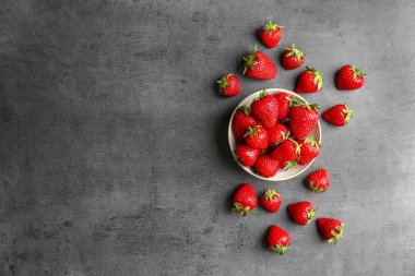 Gri arka plan üzerinde olgun kırmızı çilek ile düz yatıyordu kompozisyon