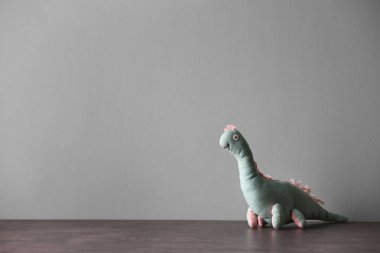 Açık renkli karşı masada terk edilmiş oyuncak dinozor. Çocuk psikologu ziyaret etmek için zaman