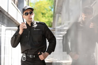 Erkek güvenlik görevlisi taşınabilir radyo vericisi açık havada kullanma