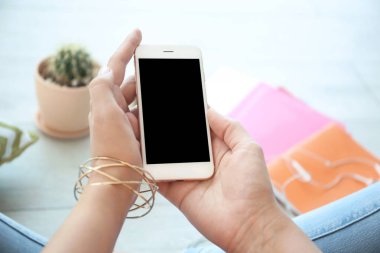 Boş ekran ile cep telefonu elinde kapalı tutan genç kadın