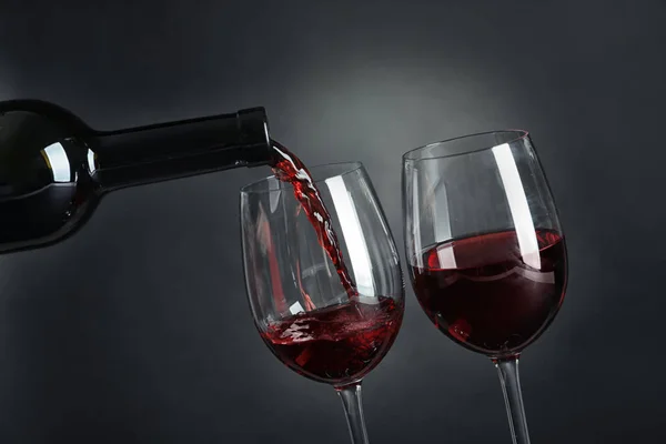 Наливаючи Смачне Червоне Вино Склянку Темному Фоні — стокове фото