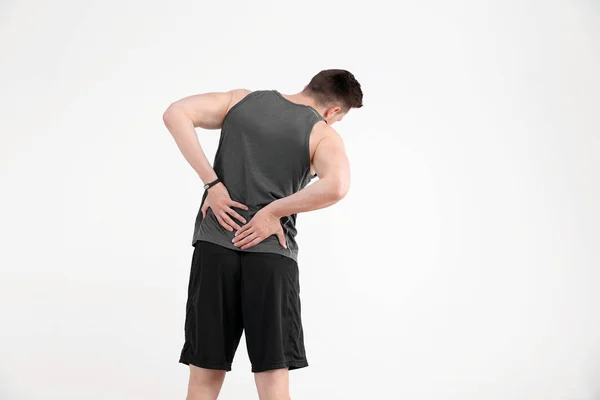 男子在运动衫遭受背部疼痛的白色背景 — 图库照片