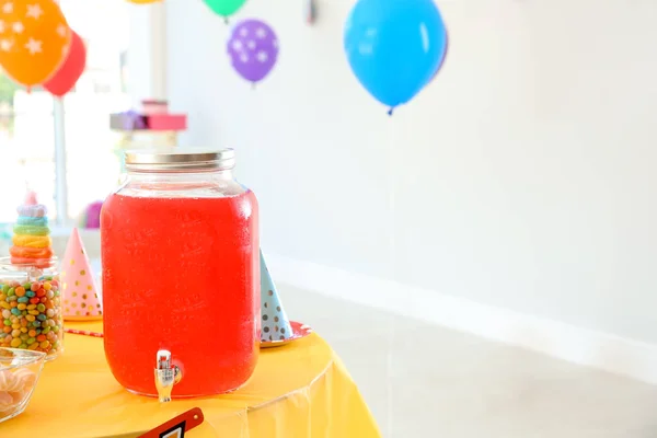 Drink dispenser with cold beverage on table at birthday party indoors