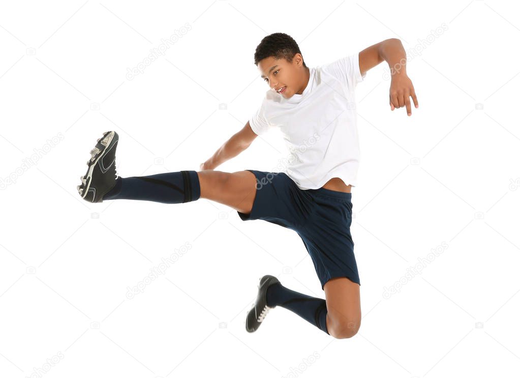 Teenage African-American boy playing football on white background