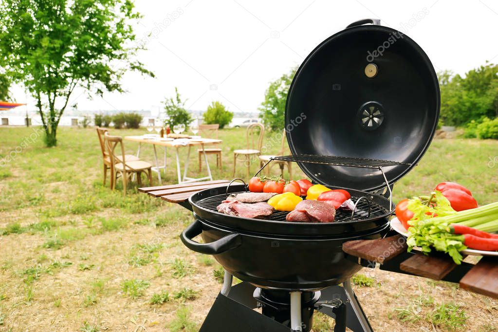 Modern grill with meat and vegetables outdoors
