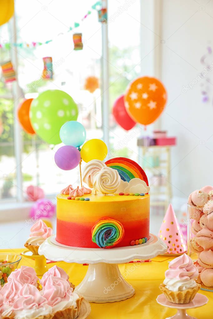 Table with birthday cake and delicious treats indoors