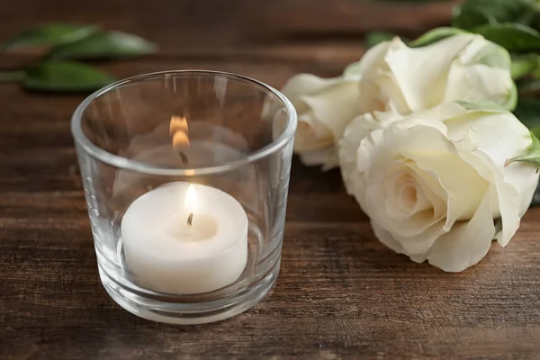 Γυαλί Αναμμένο Κερί Κερί Κοντά Λουλούδια Στο Ξύλινο Τραπέζι — Φωτογραφία Αρχείου