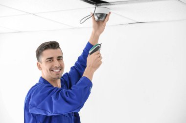 teknisyen kapalı tavan üzerine kapalı devre kamera kuruyor