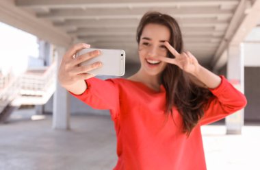 Selfie telefon ile açık havada alarak çekici genç kadın