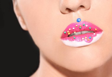 Güzel genç model siyah arka plan üzerine yaratıcı dudak makyaj ile