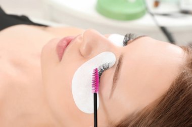 Genç kadın kirpik uzantıları yordamı, closeup geçiyor