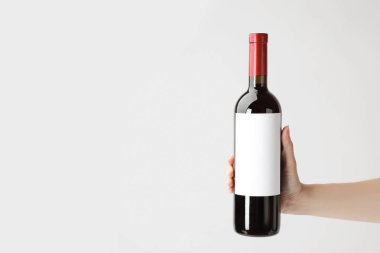 Beyaz zemin üzerine lezzetli şarap şişesiyle tutan kadın