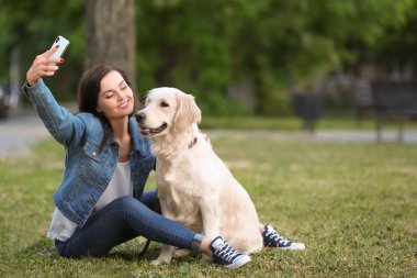 Genç kadın selfie köpeğini birlikte parkta alıyor. Evde beslenen hayvan kaygı