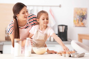Anne ve kızı mutfakta masada hamur yapma
