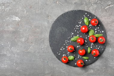 Domates ve fesleğen gri arka plan üzerinde düz yatıyordu kompozisyonu