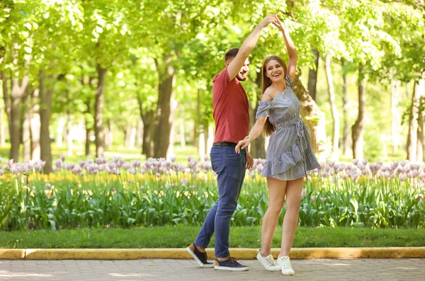 Happy young couple in green park on sunny spring day