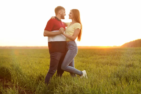 快乐的年轻夫妇在绿色领域在晴朗的春天天 — 图库照片
